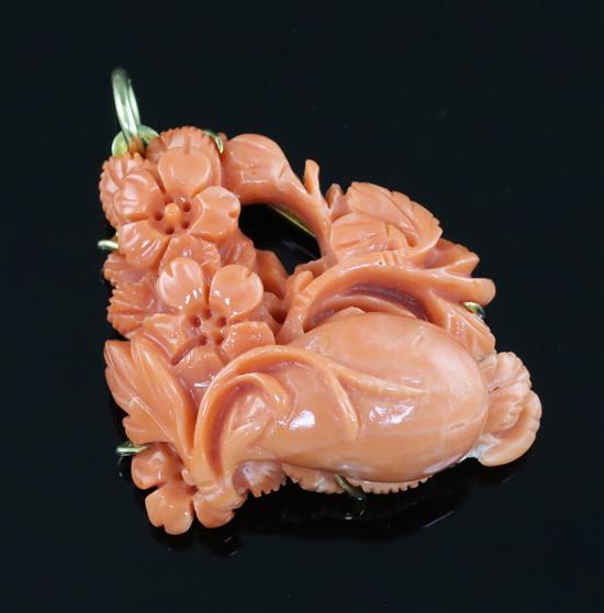 A 20th century 18ct gold mounted coral pendant, carved with flowers, gross weight 20.4 grams.